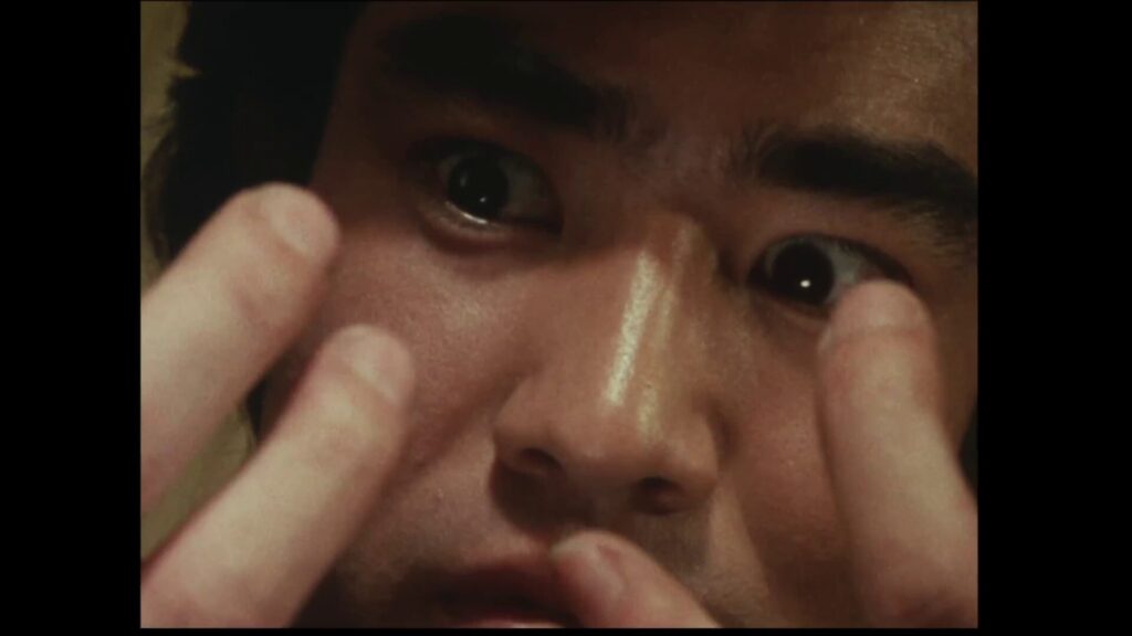 自分の手を見つめ、驚きと緊張が混ざった鋭い表情を見せる本郷猛（藤岡弘、）のクローズアップ画像。